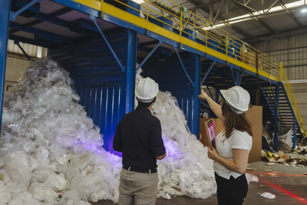 Profissionais analisam resíduos plásticos em um centro industrial de triagem e reciclagem, etapa essencial da logística reversa do plástico. O processo permite coletar, separar e reintroduzir materiais plásticos no ciclo produtivo, reduzindo impactos ambientais e promovendo economia circular nas indústrias.