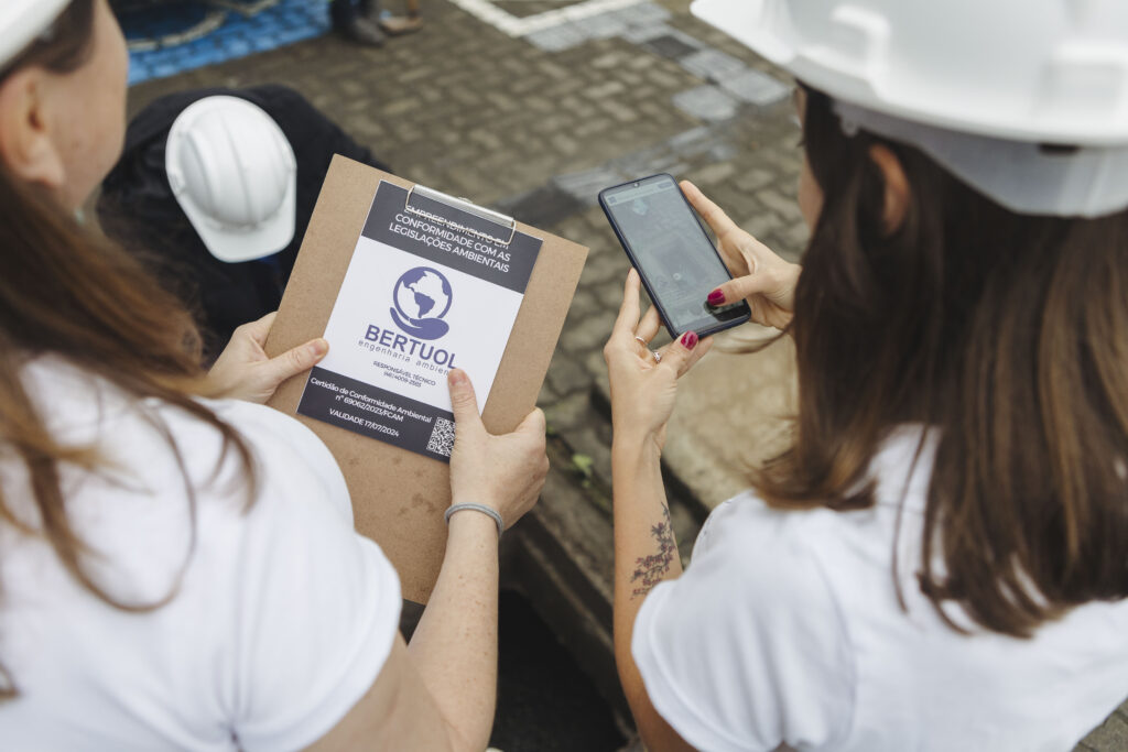 Profissionais utilizando checklist de conformidade ambiental da Bertuol Engenharia Ambiental durante vistoria técnica em campo.